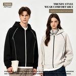 Man in a black zip hoodie and woman in a light grey zip hoodie, both with contrast topstitching on the sleeves