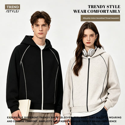 Man in a black zip hoodie and woman in a light grey zip hoodie, both with contrast topstitching on the sleeves