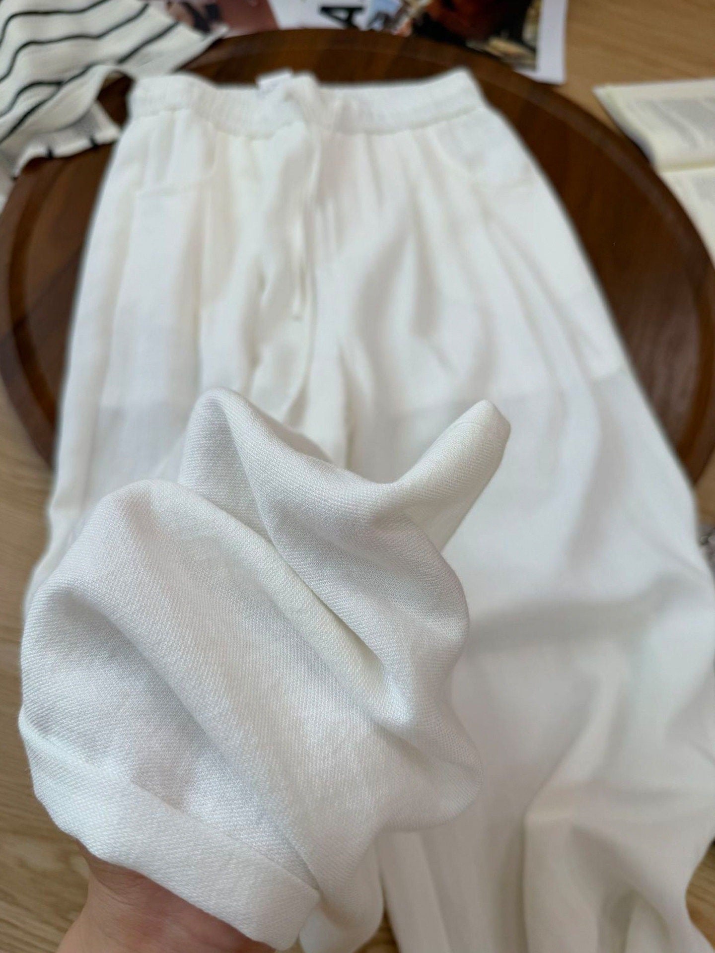 Yellow cotton linen straight-leg pants with elastic waist on a wooden tray