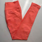 Coral pink seamless leggings with the curved knitted seat panel visible on the flat lay