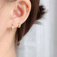Hoop earrings worn under tucked back hair at the office