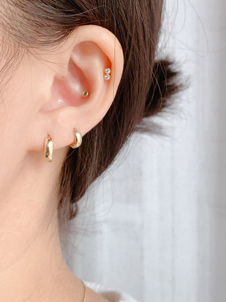 Hoop earrings worn under tucked back hair at the office