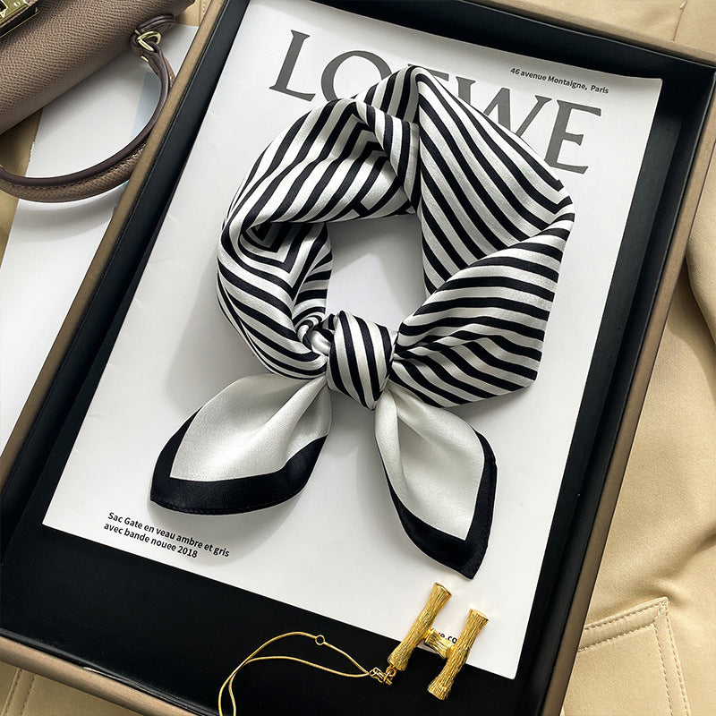 Black and white striped printed square scarf with a satin sheen and hemmed edges, shown displayed