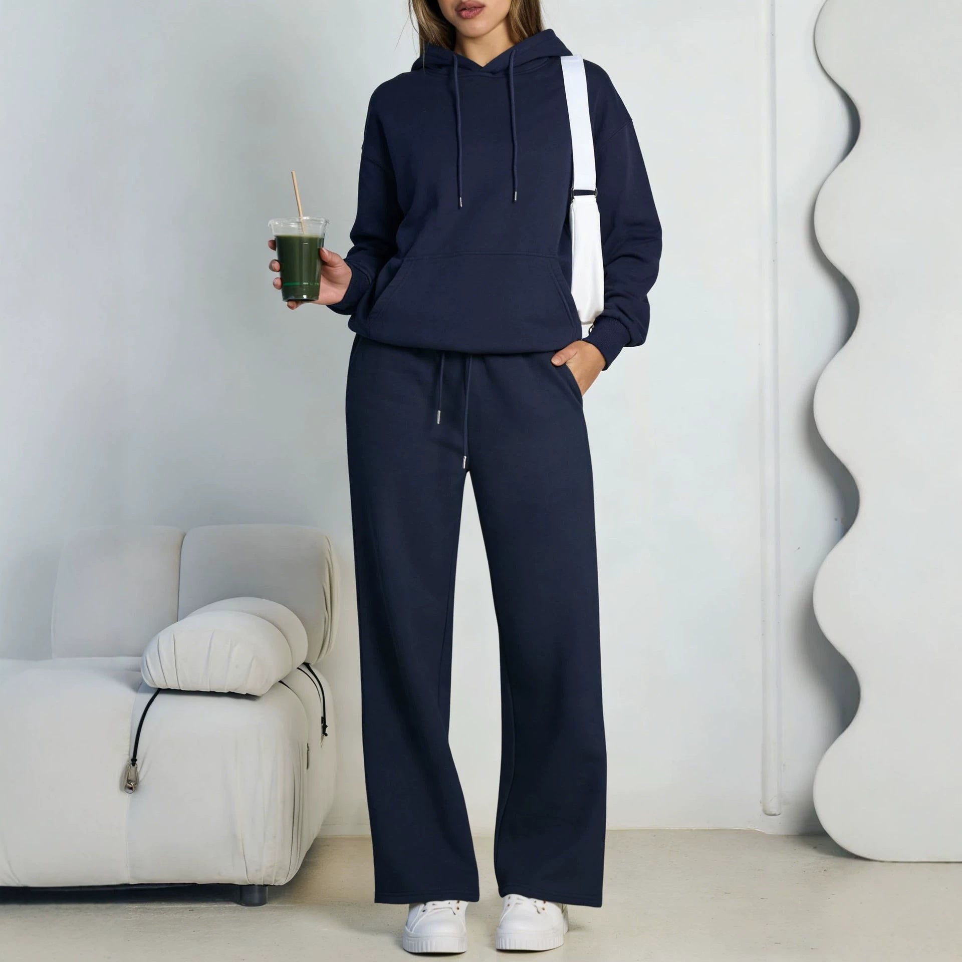 Navy blue fleece hooded sweatshirt and wide-leg sweatpants set worn by a model