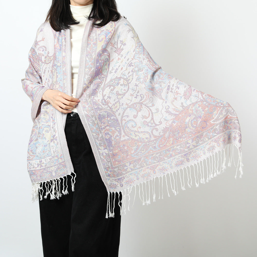Woman in an ivory paisley jacquard scarf held open to show the pastel pink, blue and lilac pattern