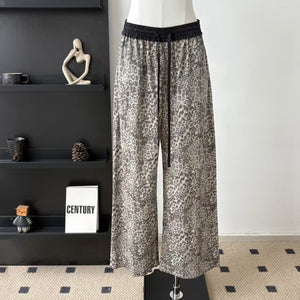 Front view of grey and charcoal leopard trousers with black contrast waistband and full-length leg