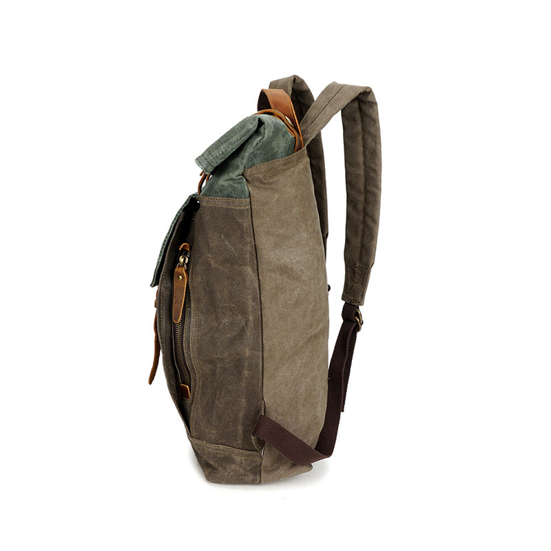 Side view of olive canvas backpack with brown shoulder strap and zip detail on the side panel