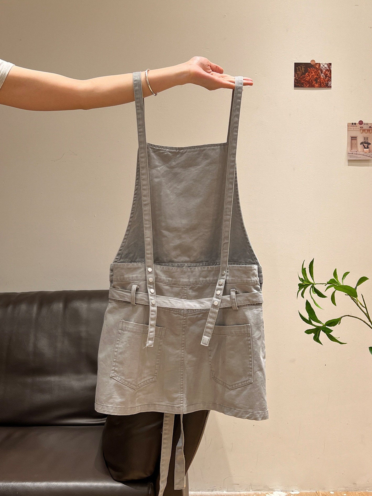 Gray washed suspender pinafore dress held up showing straps and front pockets