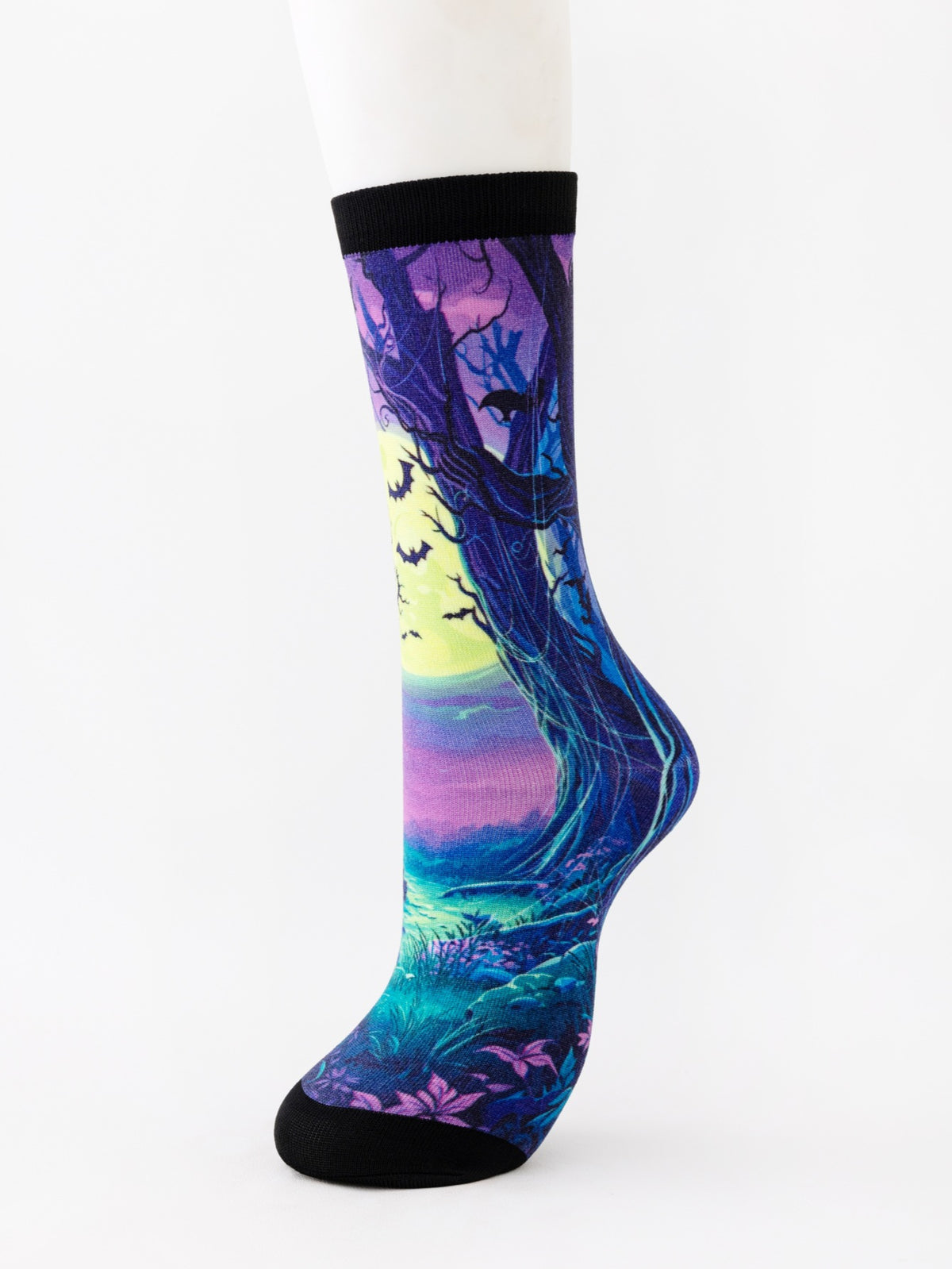 Mid-calf sock on a mannequin printed with a twisted blue tree under a pale moon with bats