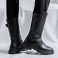 Two tall black buckle boots seen from the side, one showing the zipper, with lugged rubber soles