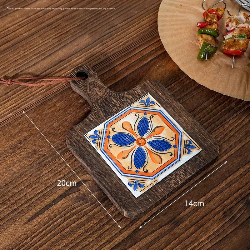 Wood trivet with a blue and orange petal tile on planks, marked 20 cm by 14 cm