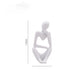 Abstract resin thinker figurine seated with an open triangle between the arms and knees