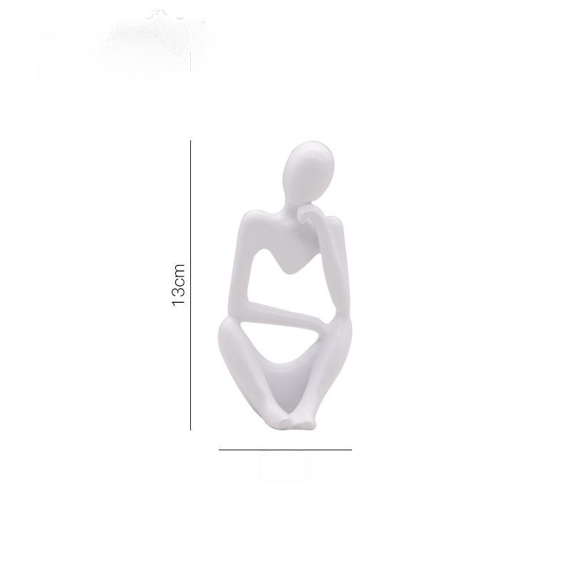 Abstract resin thinker figurine seated with an open triangle between the arms and knees