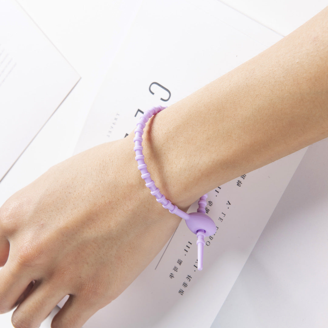 Tadpole silicone tie looped around a wrist to show how flexible the strap is