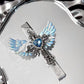 Angel wings cross lighter with iridescent blue wings and a blue heart rhinestone on a silver mirror tray