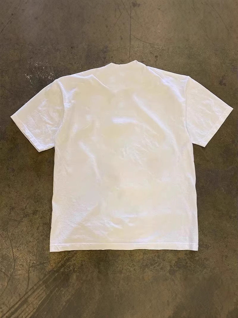 Plain white back of the oversized heavyweight cotton tee laid flat on the floor