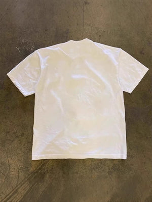 Plain white back of the oversized heavyweight cotton tee laid flat on the floor