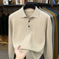 Khaki beige long sleeve knit polo shirt on a hanger with ribbed hem, fabric held by hand