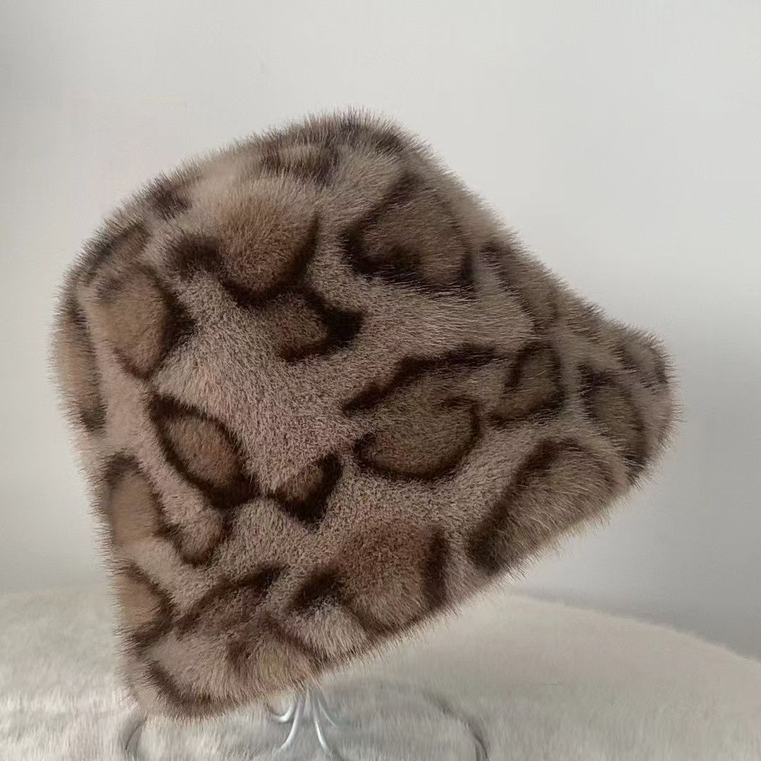 Taupe leopard print plush bucket hat with brown spots on a clear stand