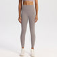 Wide high-rise waistband yoga leggings, nylon spandex knit, worn against a studio wall