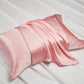Silk pillowcase with a fluid drape and contrast piping on a pale bed