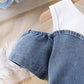 Close up of white patchwork denim panels on the girls' dress