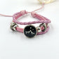 Pink braided cord bracelet with a sun charm and silver tone beads on a wrist