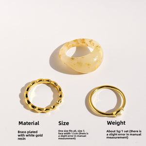 Three-piece resin and gold ring set showing cream resin dome, pearl band and beaded gold band