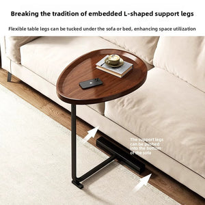 Walnut top C shaped table beside a beige sofa, legs shown sliding under the sofa frame