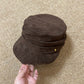 Flat top vegan suede cap with a soft pleated crown and short curved brim