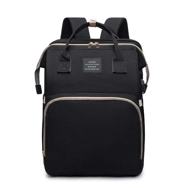 Black diaper backpack front view with two top handles, a woven label, a front zip pocket and padded back straps