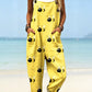 Bright yellow bee print wide-leg bib overalls with rolled cuffs on a beach, a print not among the listed options