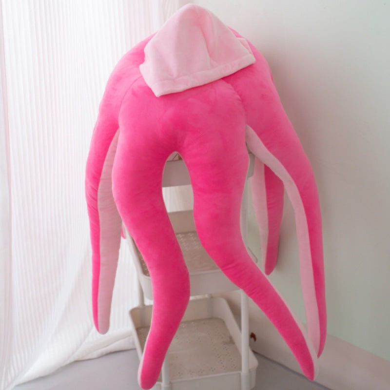 Hot pink wearable octopus plush costume with hood shown draped over a stool