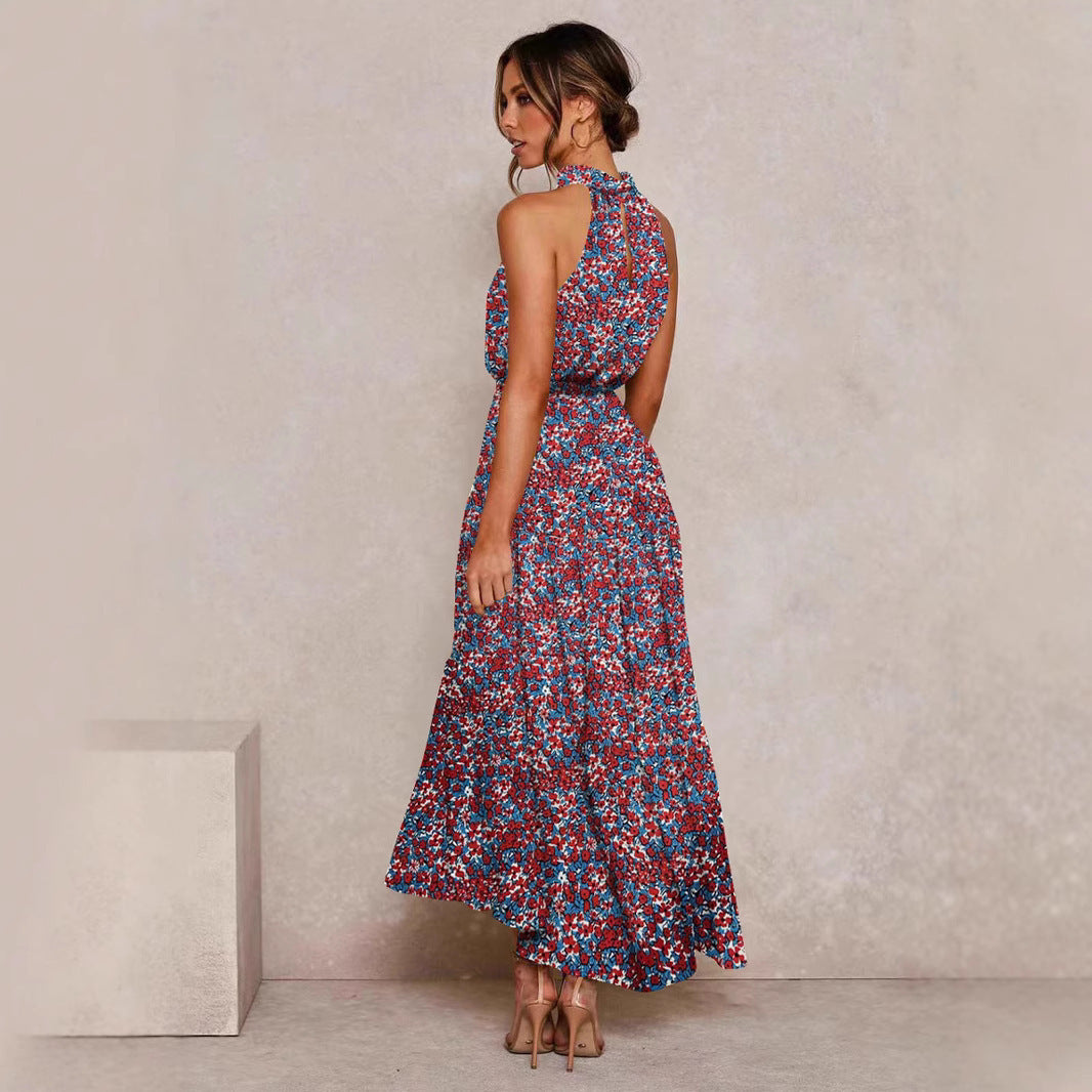 Red and purple floral halter neck sleeveless tiered swing maxi dress worn by a model