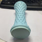 Light blue nubbed foot roller standing upright on a desk beside a keyboard