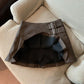 Inside of the coffee brown pleated skirt showing the lining, with two buckle straps at the side