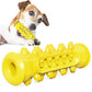 Yellow rubber dog chew toy shaped like a stick with moulded nubs and a ring at one end