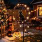 Black cat and moon solar stake light with pumpkin lanterns set in a flower border