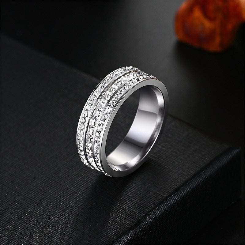 Silver tone three row cubic zirconia band ring on a black surface, size No. 11 option