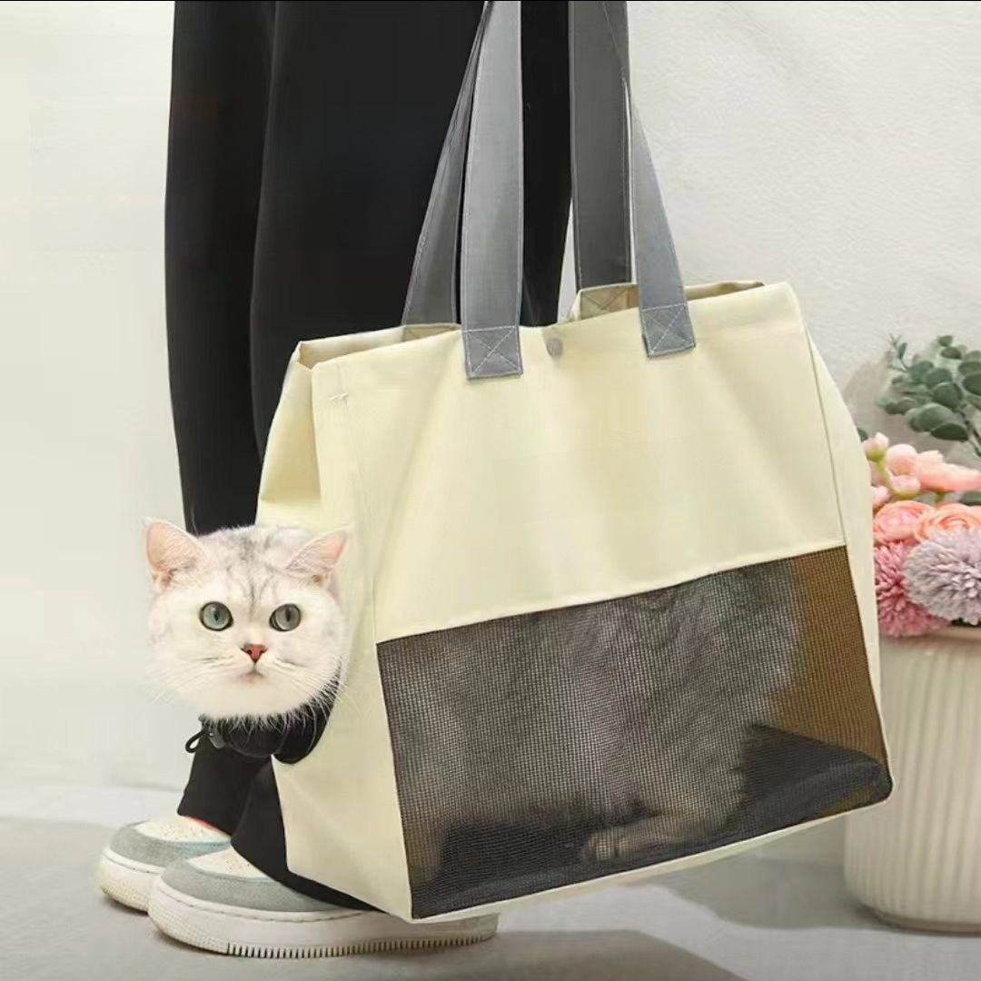 Beige cat carrier tote with a cat poking its head out the side opening and the body behind the mesh