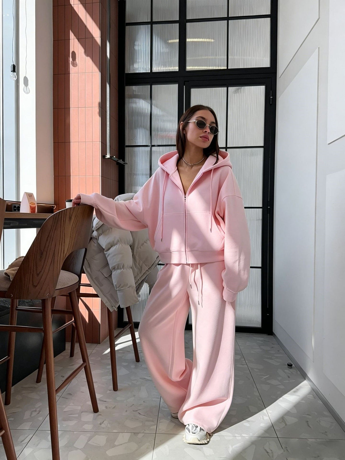 Pink zip-up hoodie and wide leg trousers set worn by a woman, option photo for size S