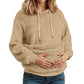 Sand plush fleece hoodie on a model with both hands in the large front pocket