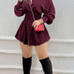Wine red button front mini shirt dress with smocked waist and long sleeves, with tall black boots and a red bag