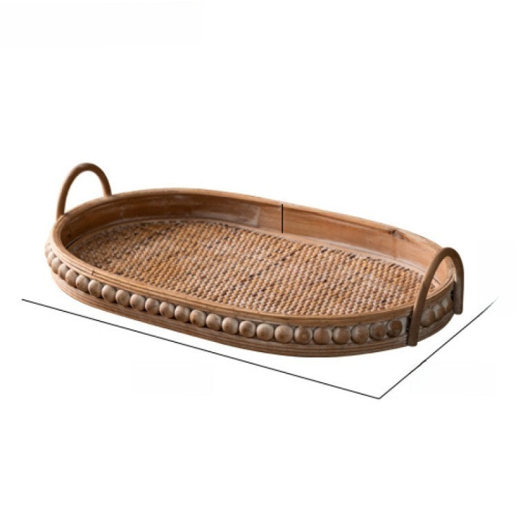 Medium oval rattan tray with woven base, studded wooden rim and two arched handles on white, Medium size option
