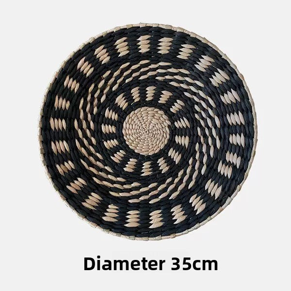 Hand-woven straw wall decor disc detail showing the raised coiled grass rows