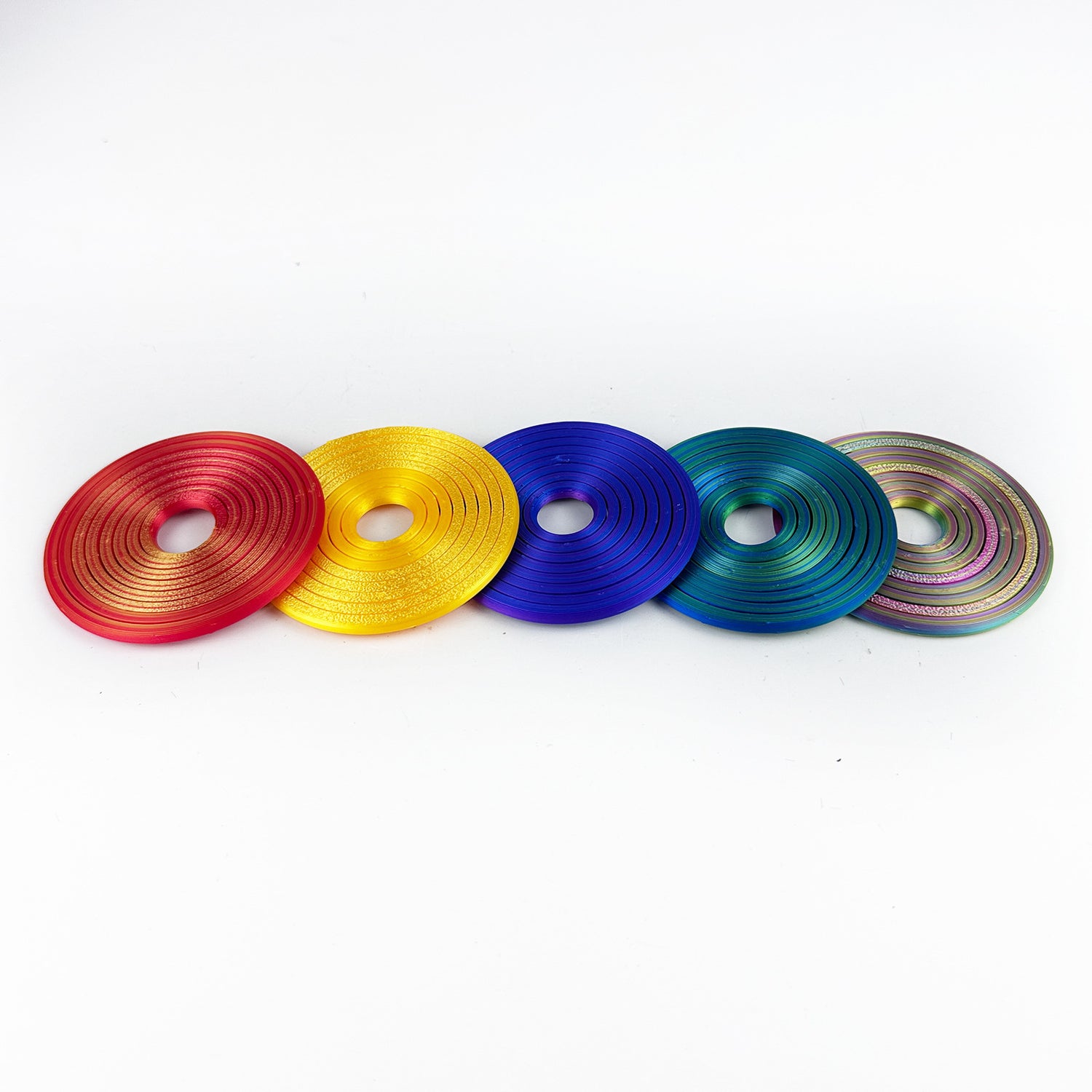 Five nested gyro ring fidgets in a row, red gold, gold, blue purple, blue green and rainbow