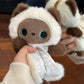 Squishy bean bag plush animal toy shown in hand, weighted body and cotton apron detail
