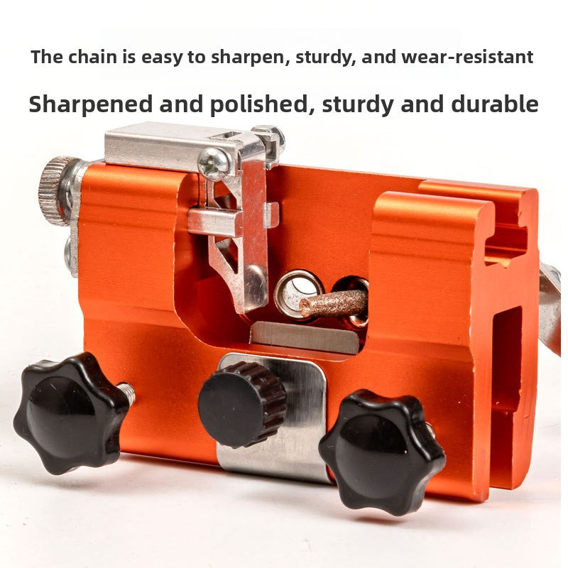 Orange manual chainsaw chain sharpener with a hand crank and carbide grinding head on a bench