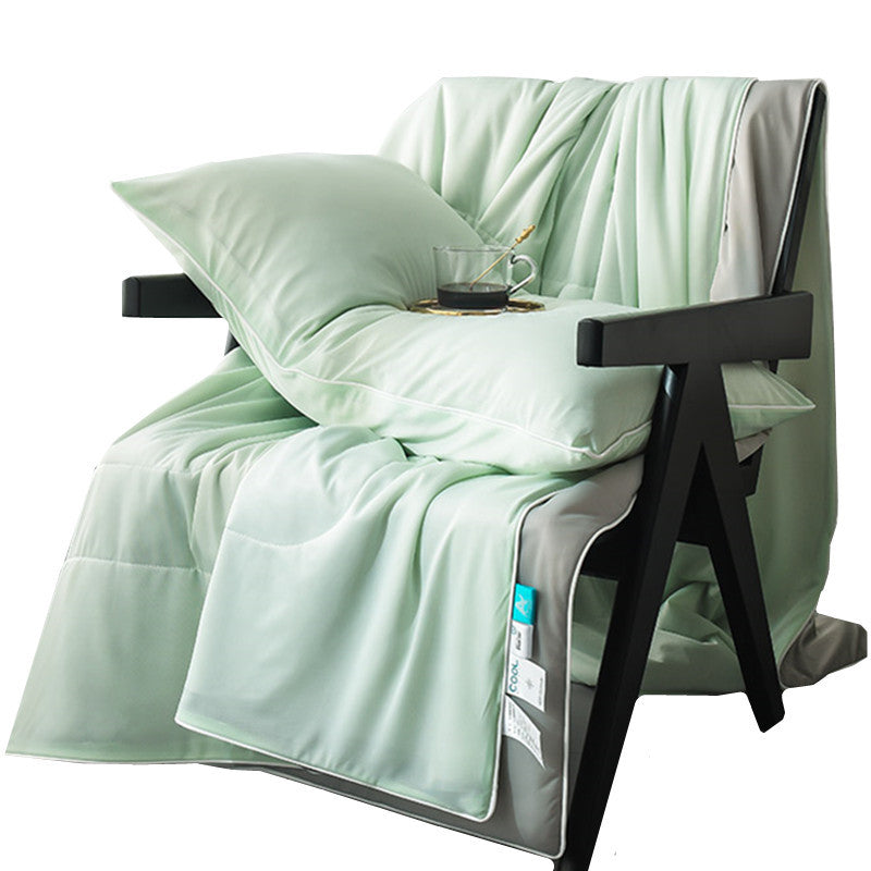 Pale green summer coverlet over an armchair, contrast piped edge and pale grey reverse showing