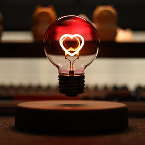 Floating light bulb with a warm heart shaped filament glowing inside pink tinted glass